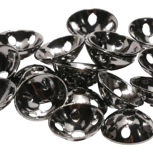 Close-up of shiny black metal Brassonics Discs with multiple holes, designed for use in fishing tackle and lure customization.