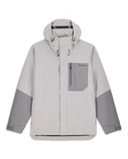 Simms Men's Challenger Rain Jacket in light gray with darker gray accents, featuring a front zipper, adjustable hood, chest pocket with zipper, and Velcro wrist closures for fishing and outdoor protection.