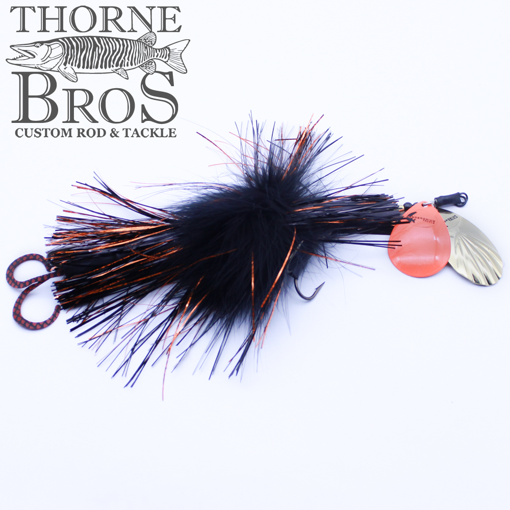 Pandemonium Tackle Marvin 78 fishing lure with black and orange synthetic fibers, feather accents, and two spinning metal blades for musky fishing, displayed on a white background.