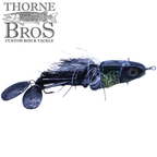 Zilla Baits Metal Head fishing lure with a black and green painted head, black and white feather skirt, and two black metal spinner blades for attracting fish.