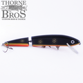 Inhaler - 8" Jointed fishing lure in black and orange with segmented body and lifelike eye, designed for musky fishing by Thorne Bros Custom Rod & Tackle.
