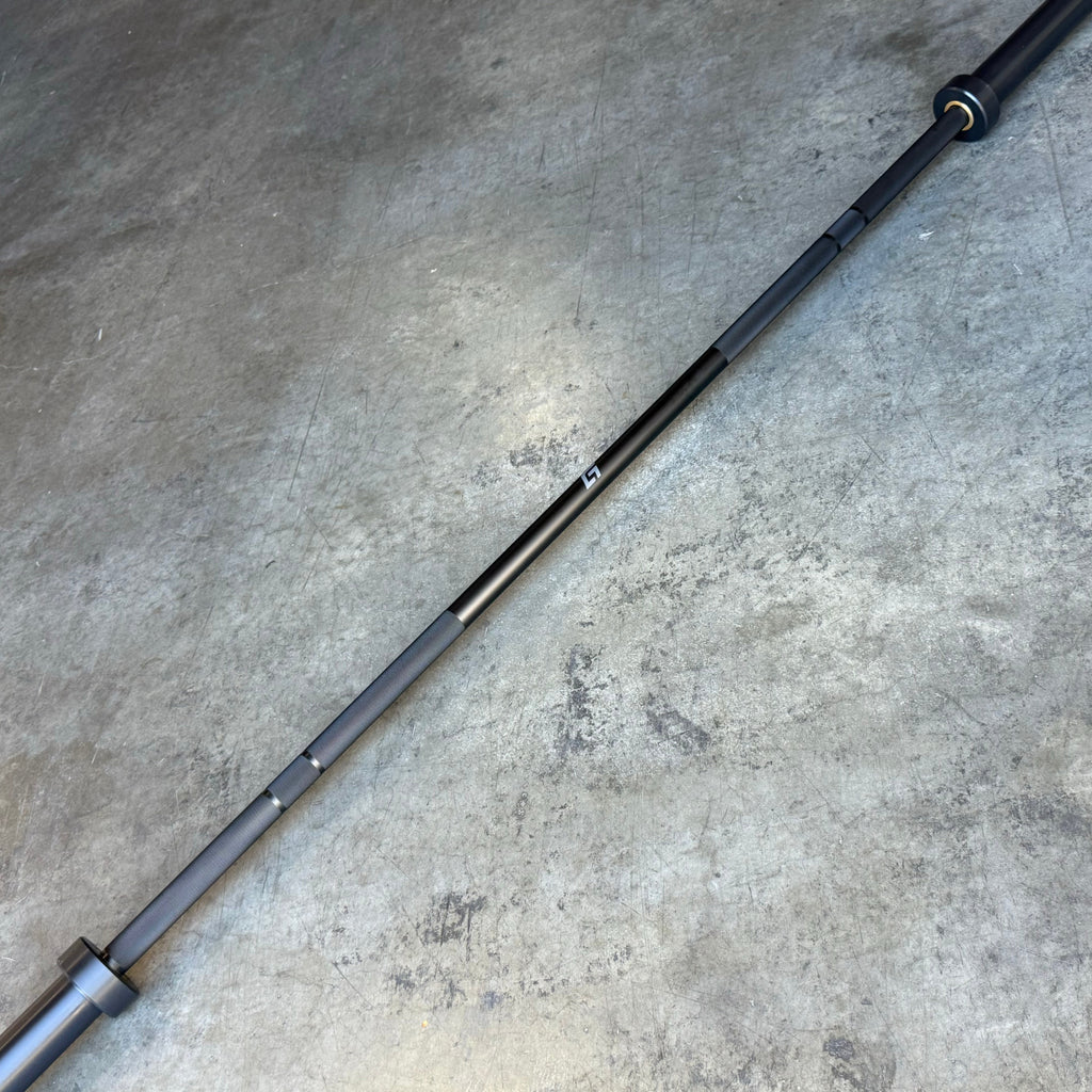 Blue 20kg Hybrid Bar shown diagonally on a concrete floor, alternate angle