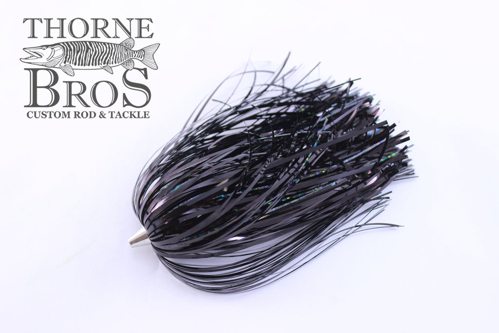 Close-up of a black Leaders & Lures Tinsel Skirt fishing lure with reflective tinsel strands, designed for use with fishing tackle and custom rods at Thorne Bros.