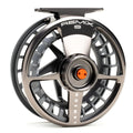 Close-up of a sleek, metallic grey Lamson Remix S fly fishing reel featuring a ventilated spool design and orange accent on the drag knob, ideal for precision casting.