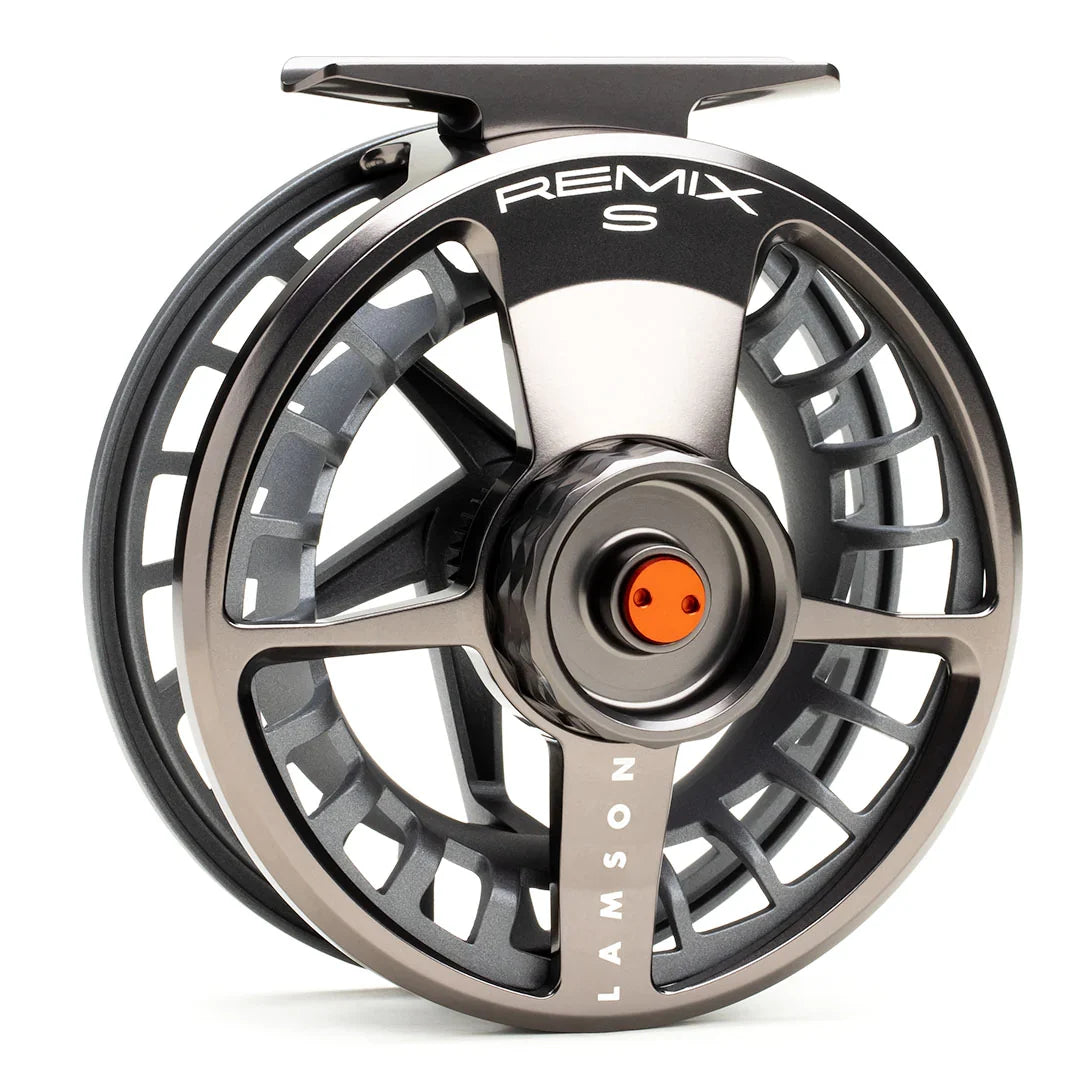 Close-up of a sleek, metallic grey Lamson Remix S fly fishing reel featuring a ventilated spool design and orange accent on the drag knob, ideal for precision casting.