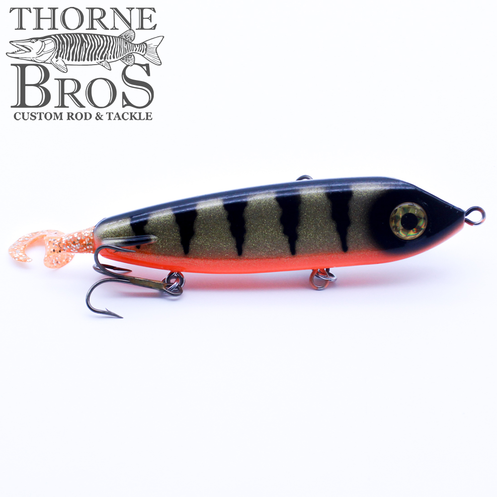 ERC Squirrely Hellhound fishing lure with a dark green and black striped body, orange sparkle tail, and two sharp treble hooks designed for musky fishing tackle.