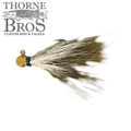 Thorne Brothers Hair Jig - Finesse features a small, detailed fishing lure with a gold-colored jig head and natural, flowing hair strands designed for finesse fishing techniques.